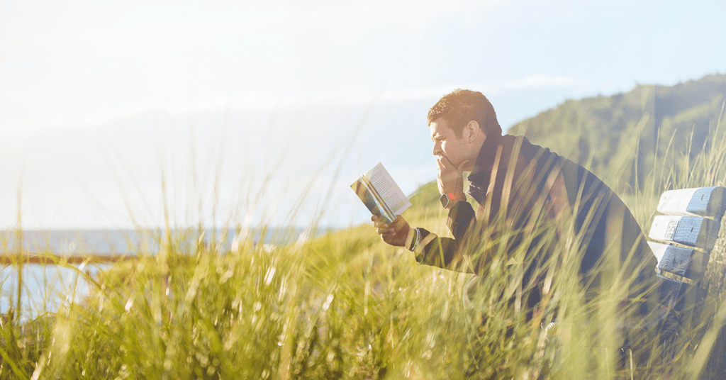man reading book on finances