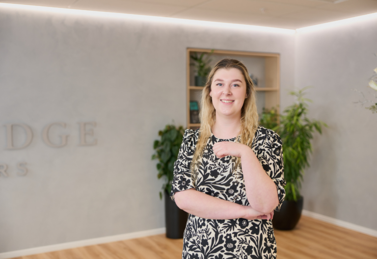 Smiling woman standing in a modern office lobby