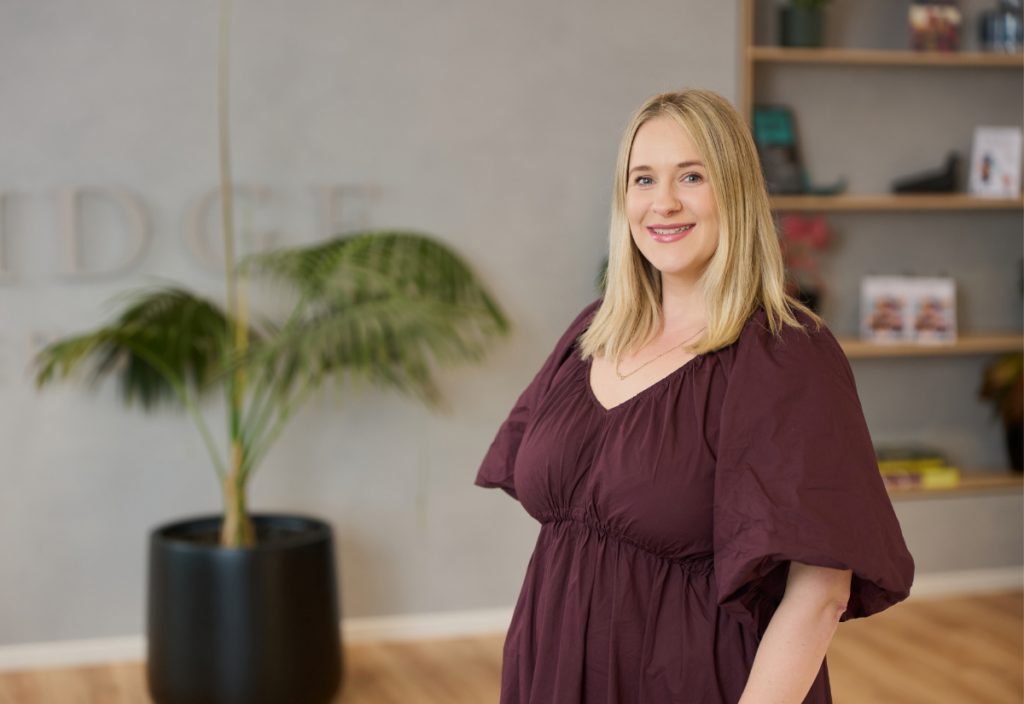 Smiling woman in burgundy dress in modern office