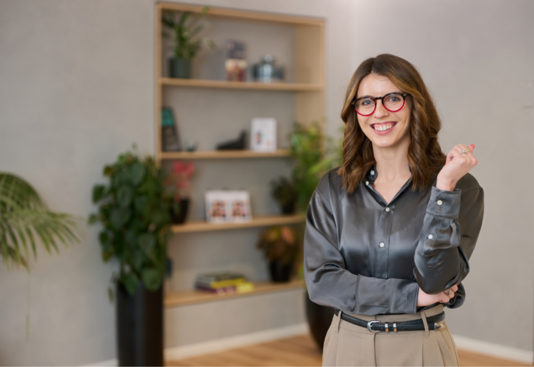 Smiling woman with red glasses in modern office