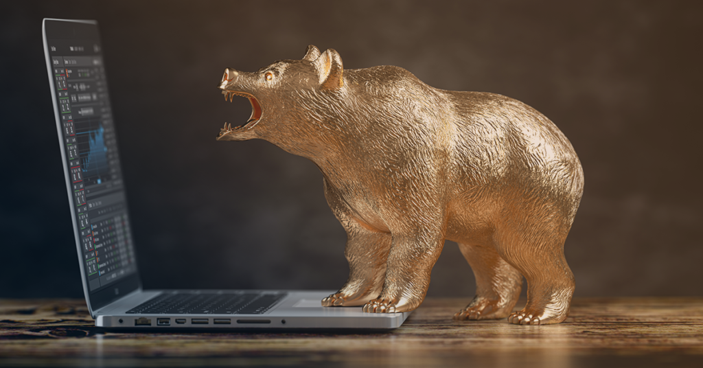 bear roaring at financial graphs on laptop