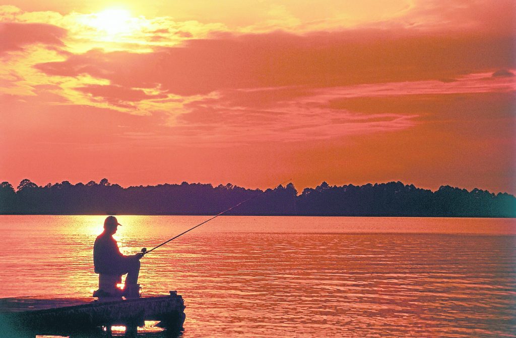 man fishing at sunset on dock in retirement