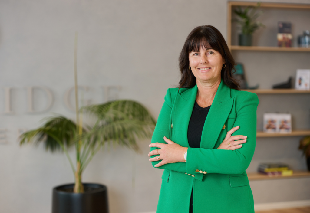Confident woman in green blazer in modern office