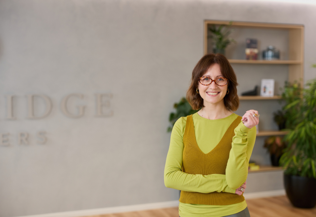 Smiling woman in modern office with plants and shelves