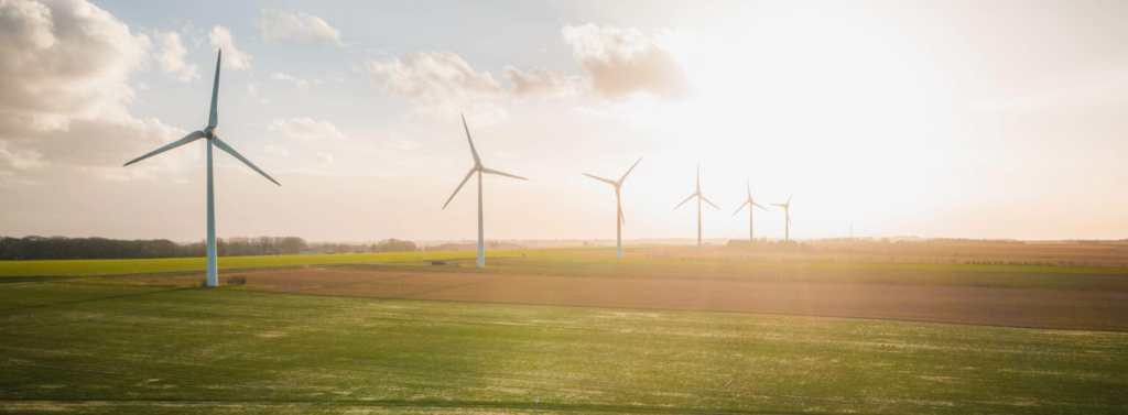 Wind turbines on open farmland at sunset