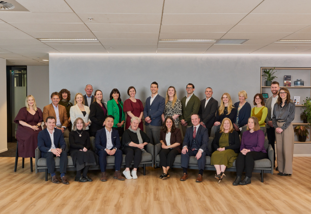 Large professional team posing together in modern office